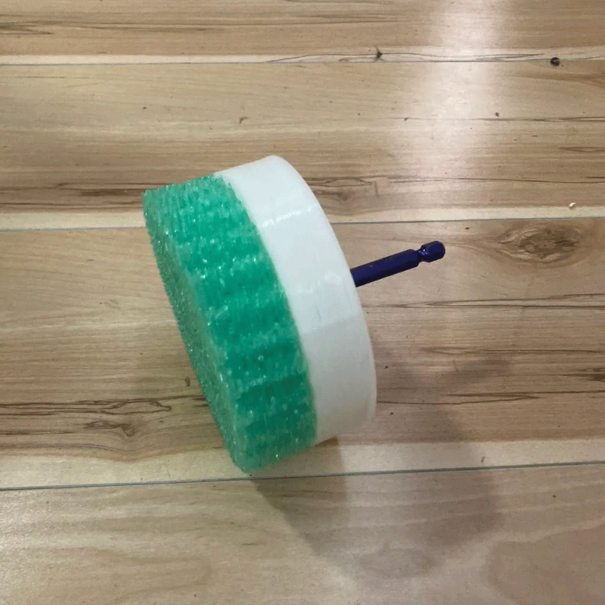 a green and white brush sitting on top of a wooden floor