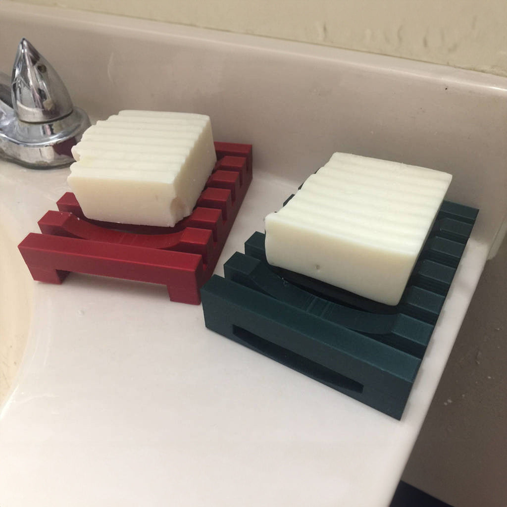 Self-draining slatted soap dish on the edge of a kitchen sink