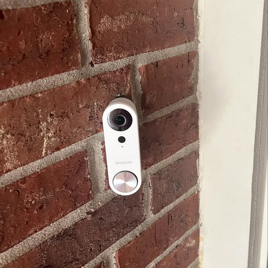 a white camera mounted to a brick wall