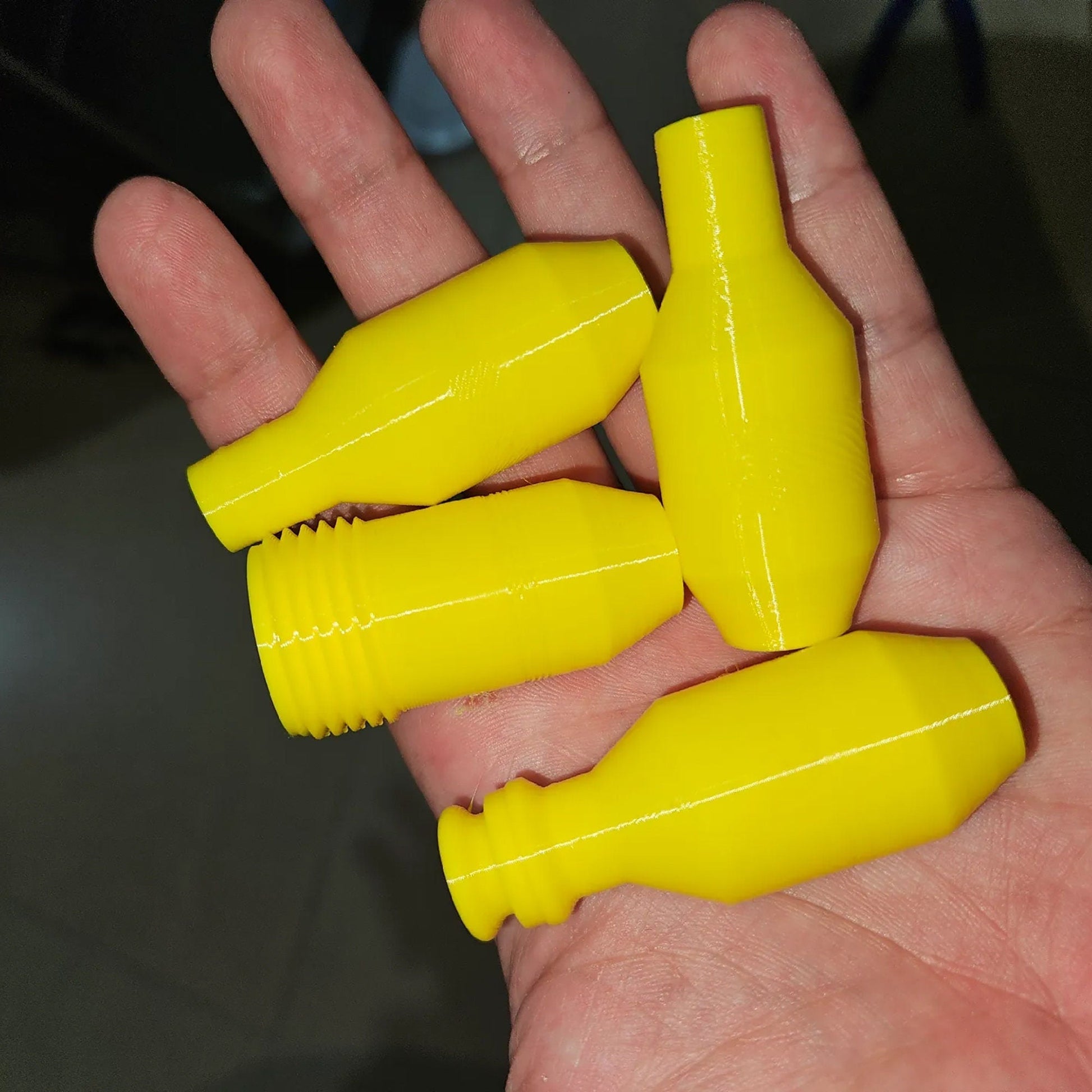 a person holding three yellow plastic bottles in their palm