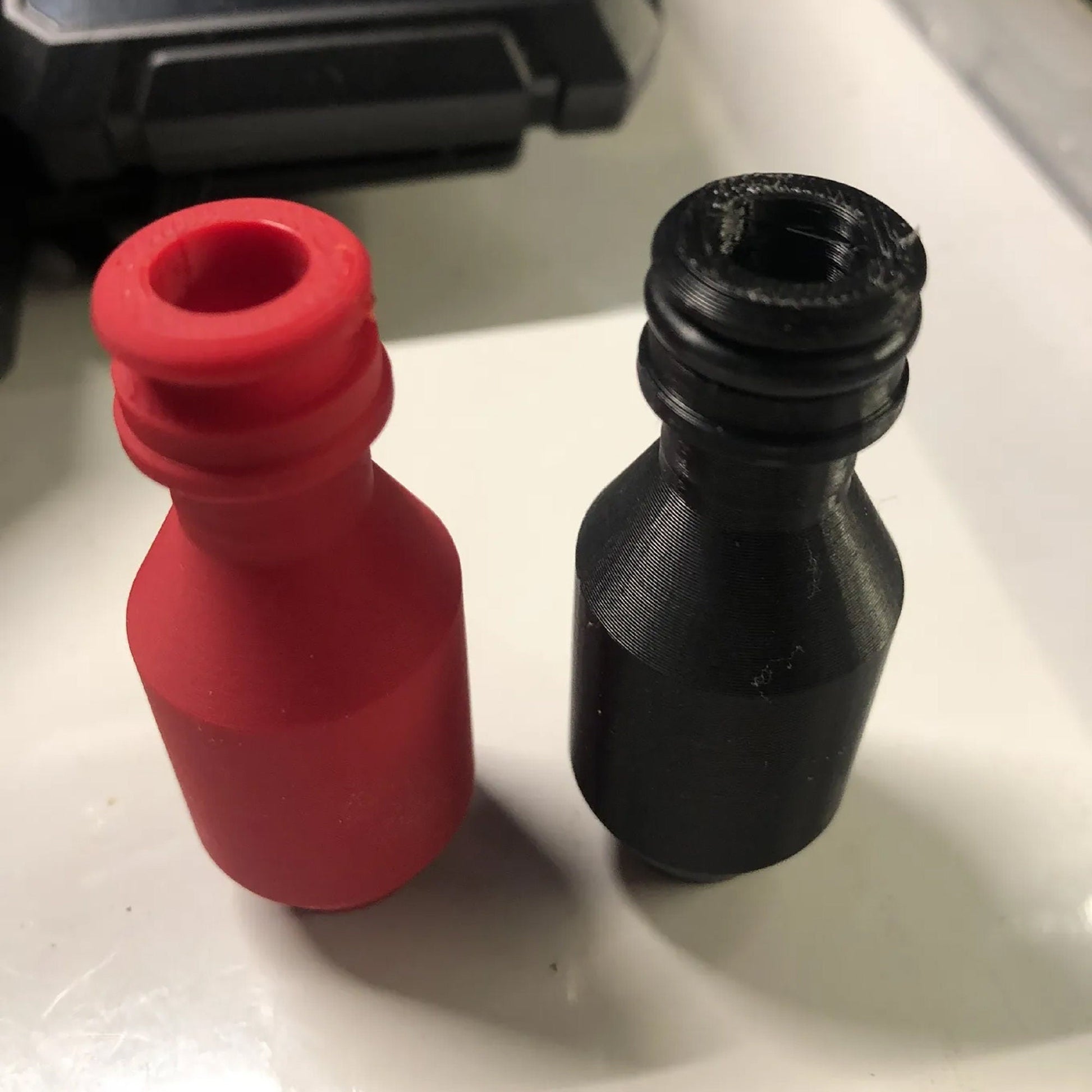 a red bottle and a black bottle sitting on a table