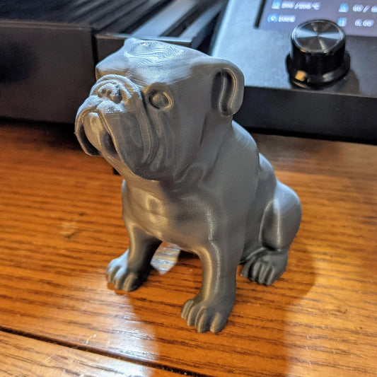 a gray dog figurine sitting on a wooden table