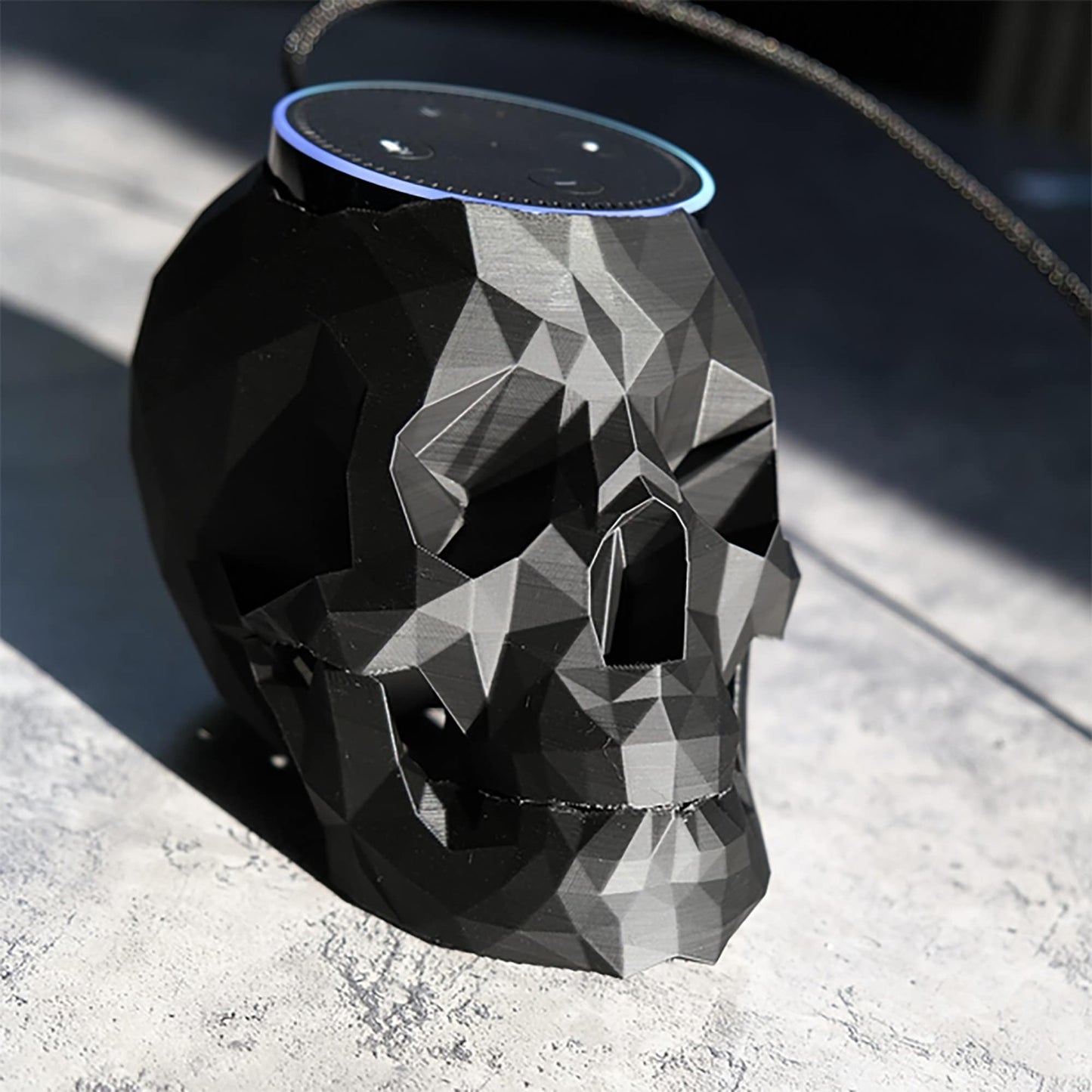 a black skull shaped speaker sitting on top of a table