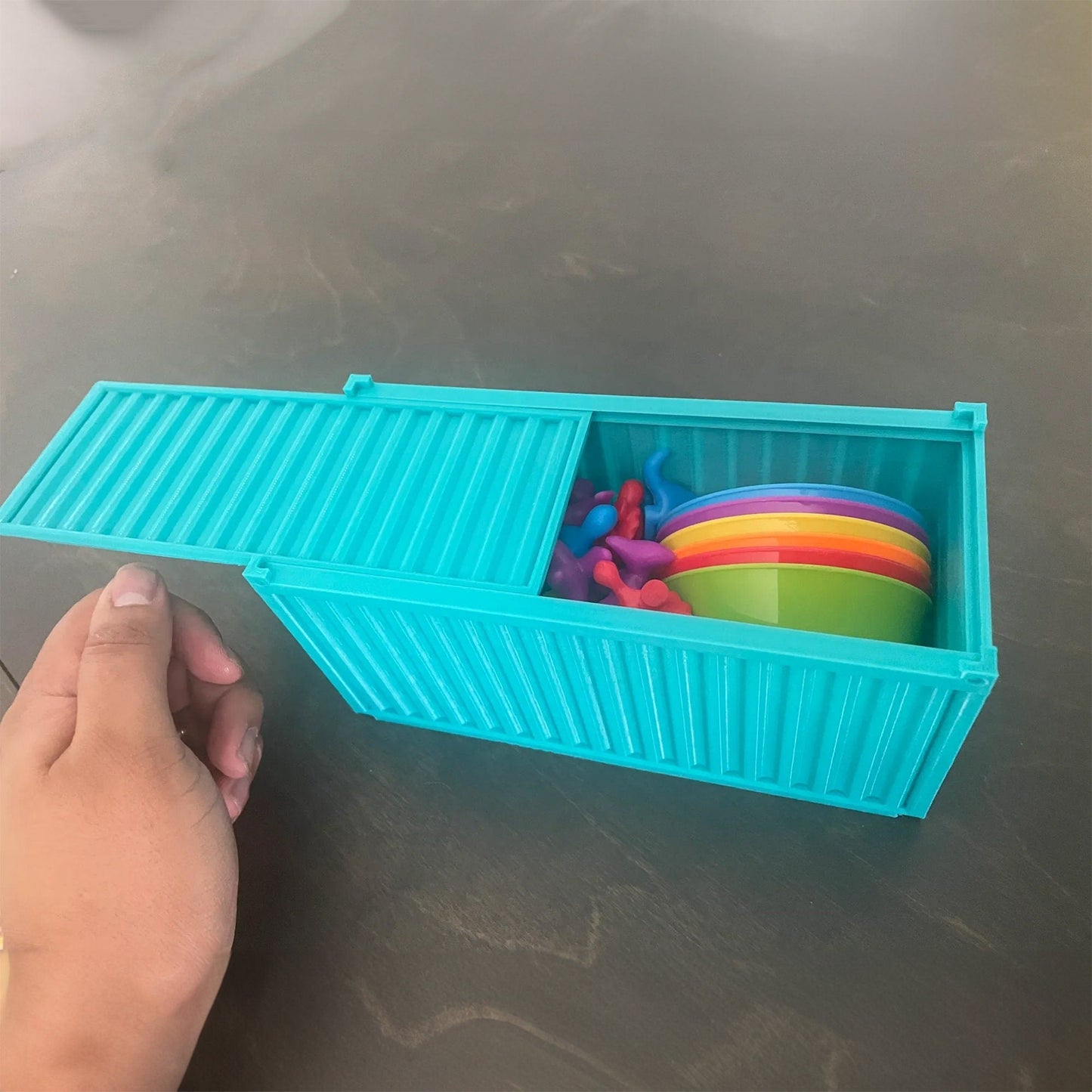 a person holding a plastic container with a bunch of toys in it