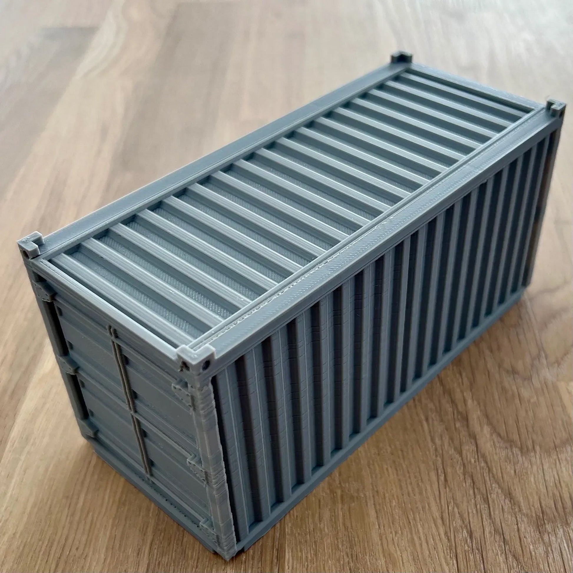 a gray container sitting on top of a wooden table