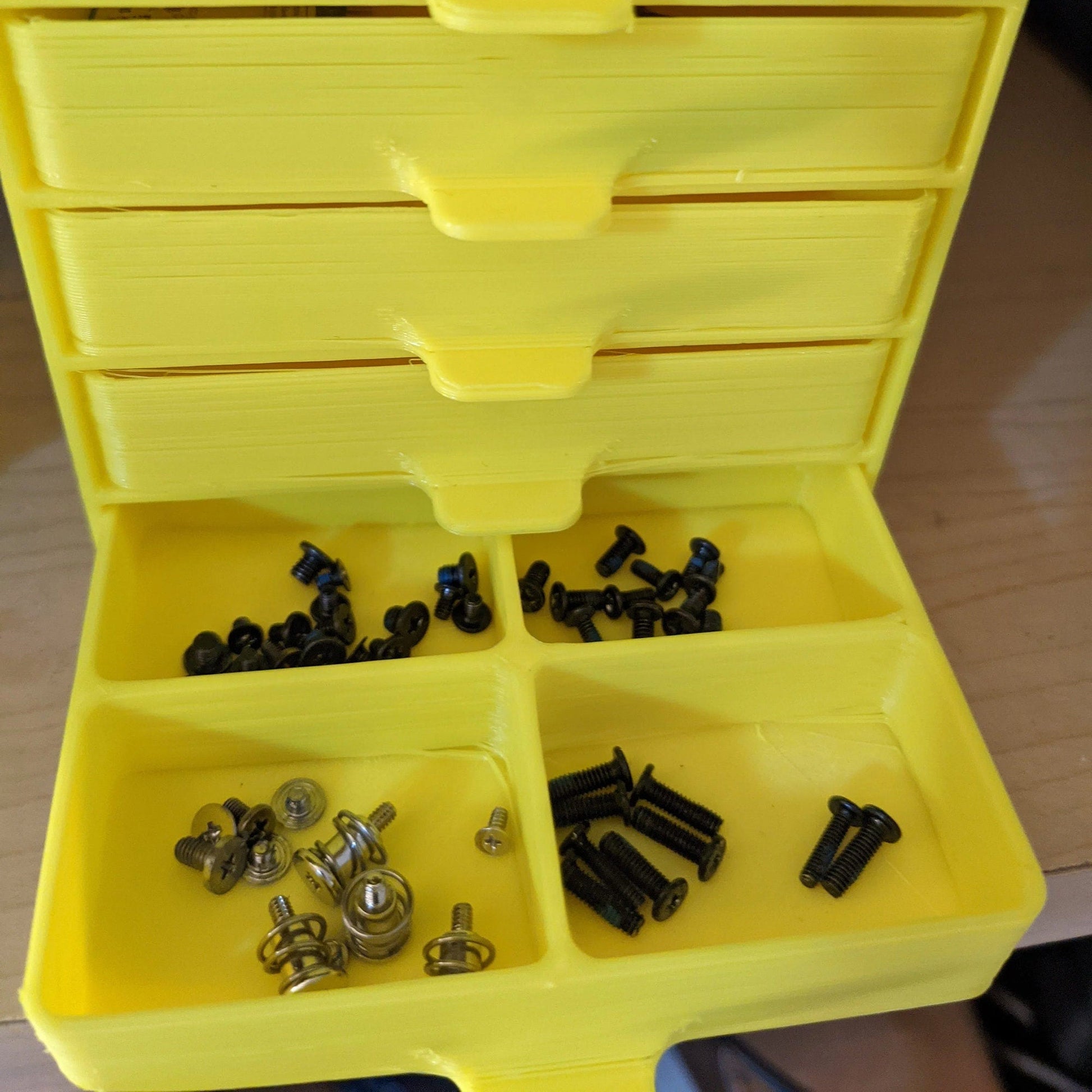 a yellow toolbox filled with lots of screws and nuts