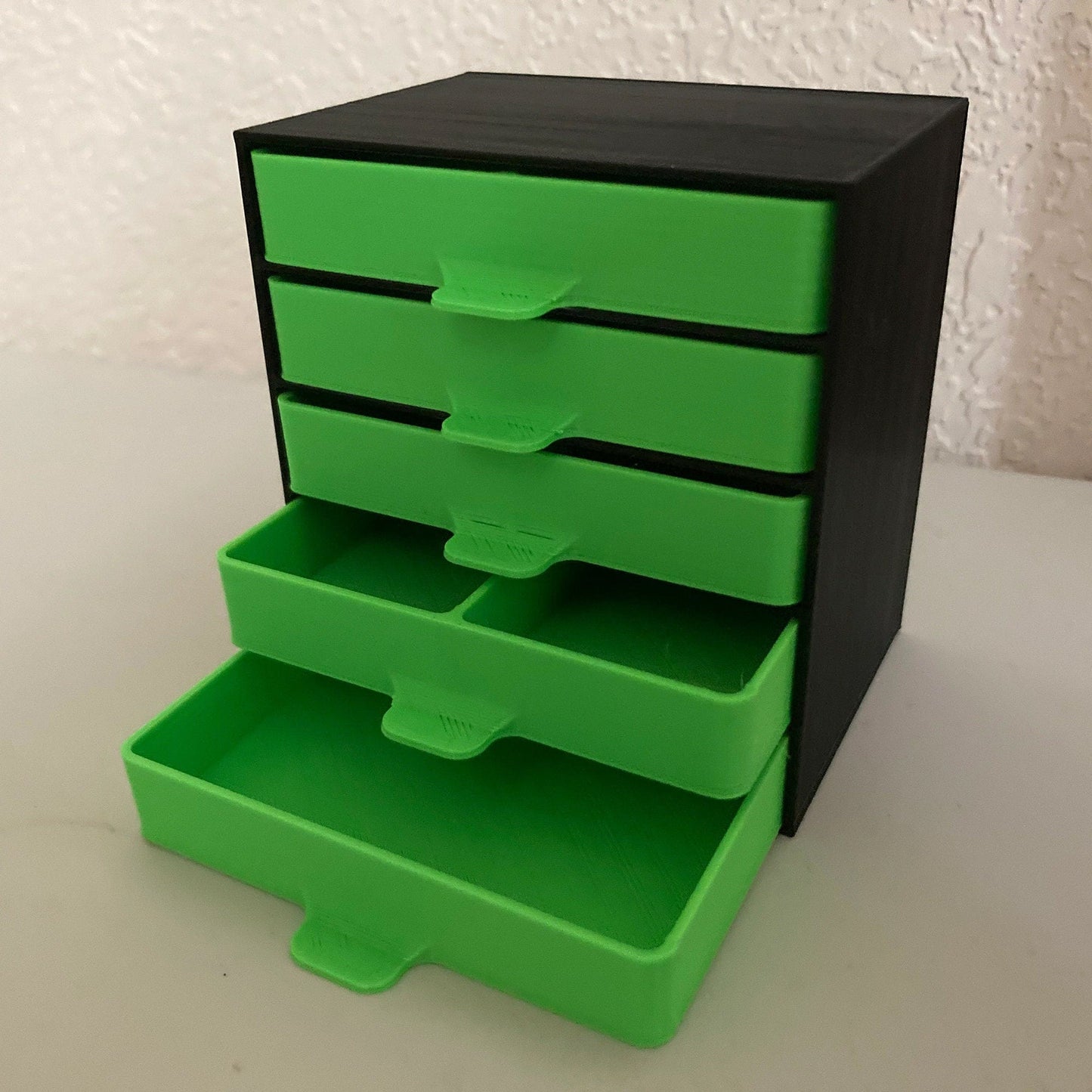 a black and green drawer with five drawers