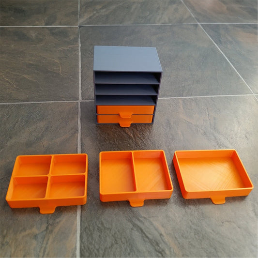 a set of four orange and black trays on a tile floor