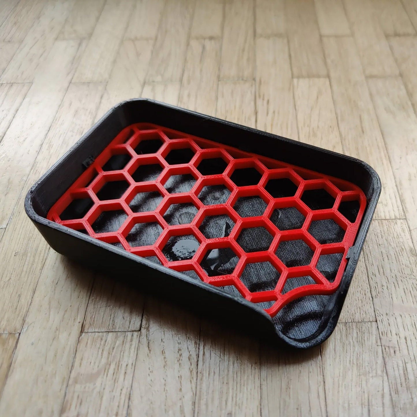 a red and black tray sitting on top of a wooden floor