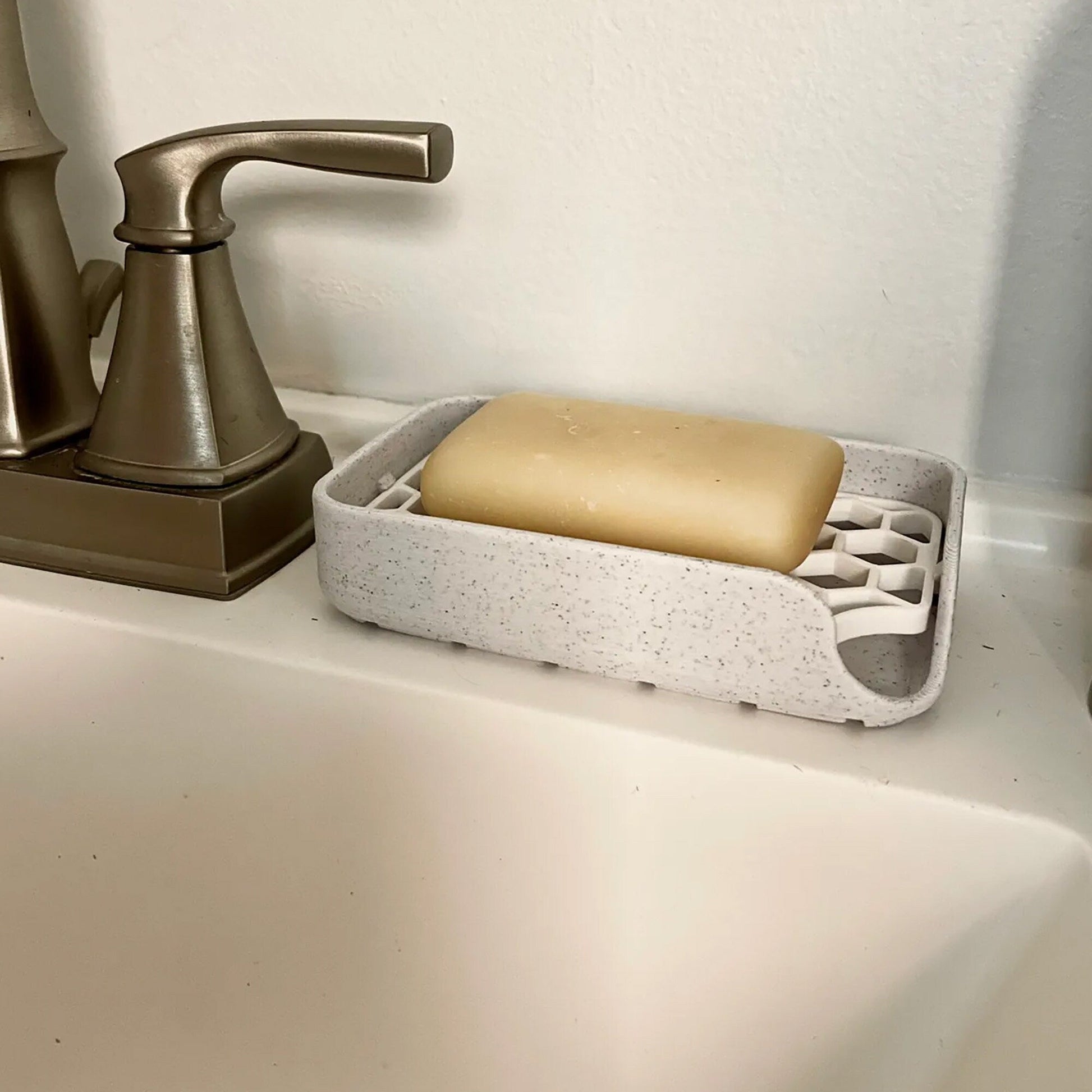 a soap dispenser sitting on a sink next to a soap disp