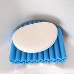 Self-draining ribbed soap dish holding a bar of soap by a sink, view 2