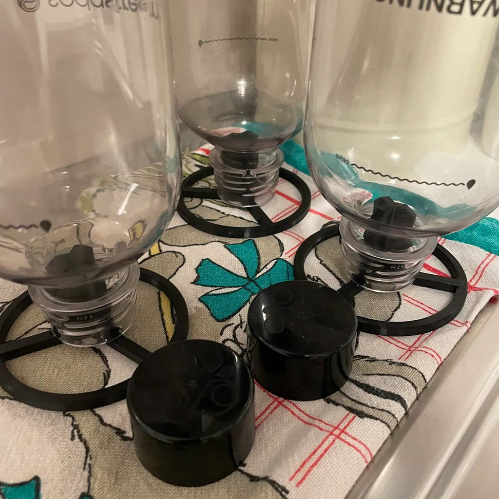 Three drying stands holding SodaStream bottles upside down to drain, view 2