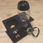 Inverted drying rack holding two SodaStream bottles and caps over a catch tray, view 2