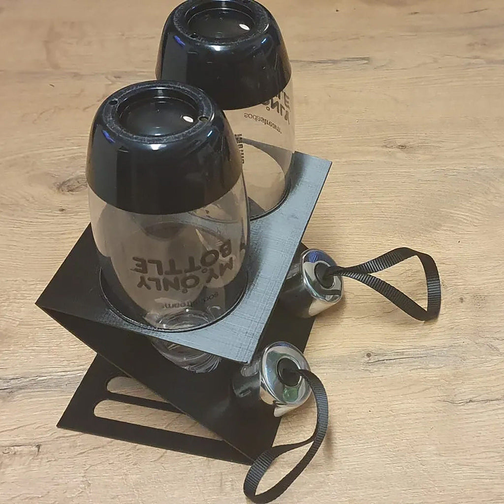 Inverted drying rack holding two SodaStream bottles and caps over a catch tray, view 4