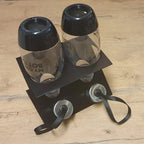 Inverted drying rack holding two SodaStream bottles and caps over a catch tray