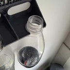 Wall-mounted drying rack holding two SodaStream Jet bottles upside down, view 2