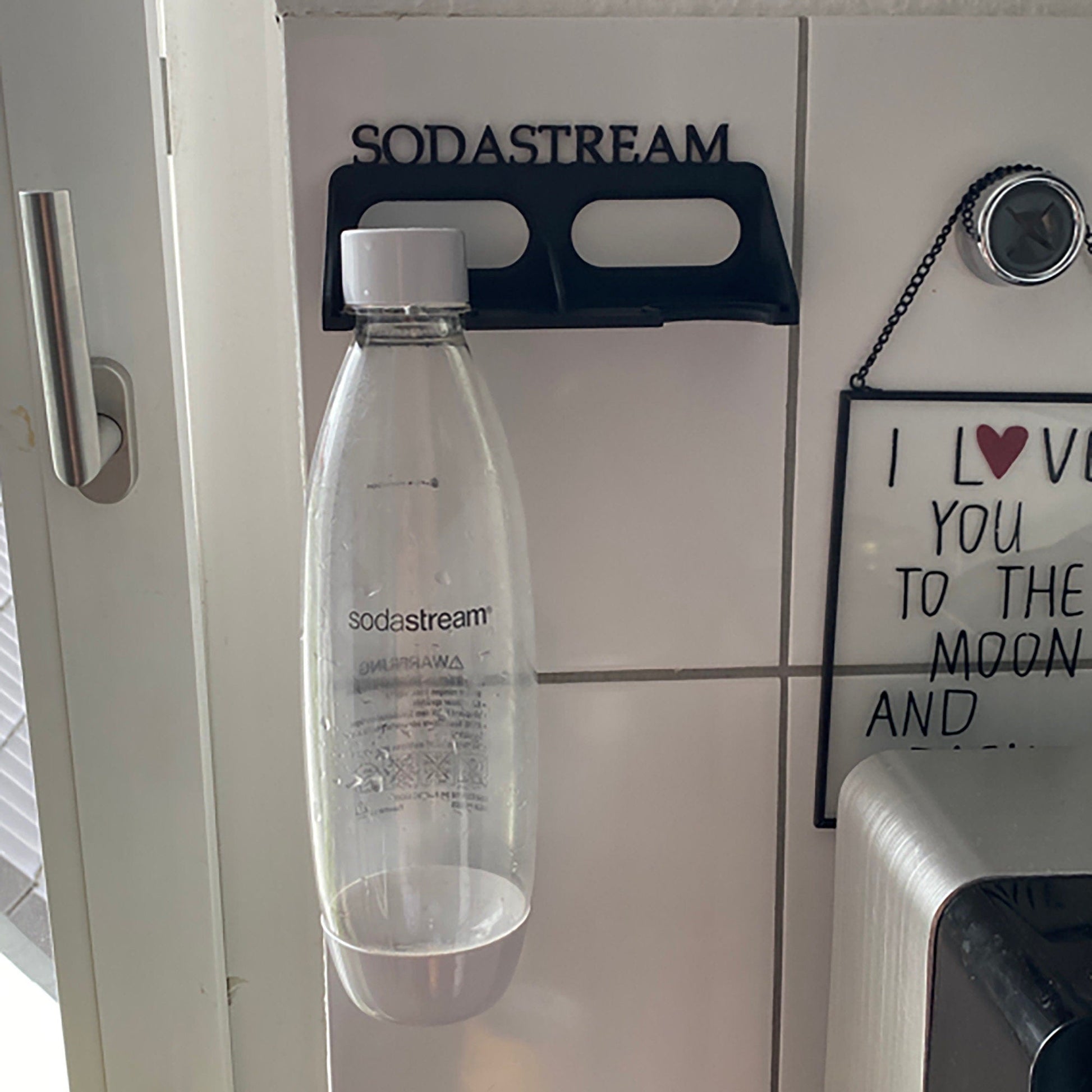 a water bottle hanging from a hook on a wall