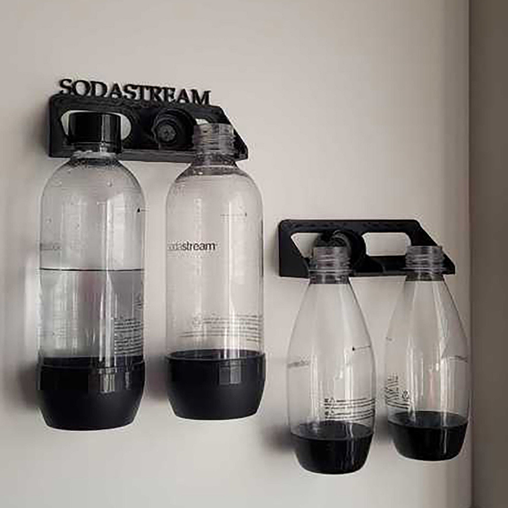 three water bottles are hanging on a wall