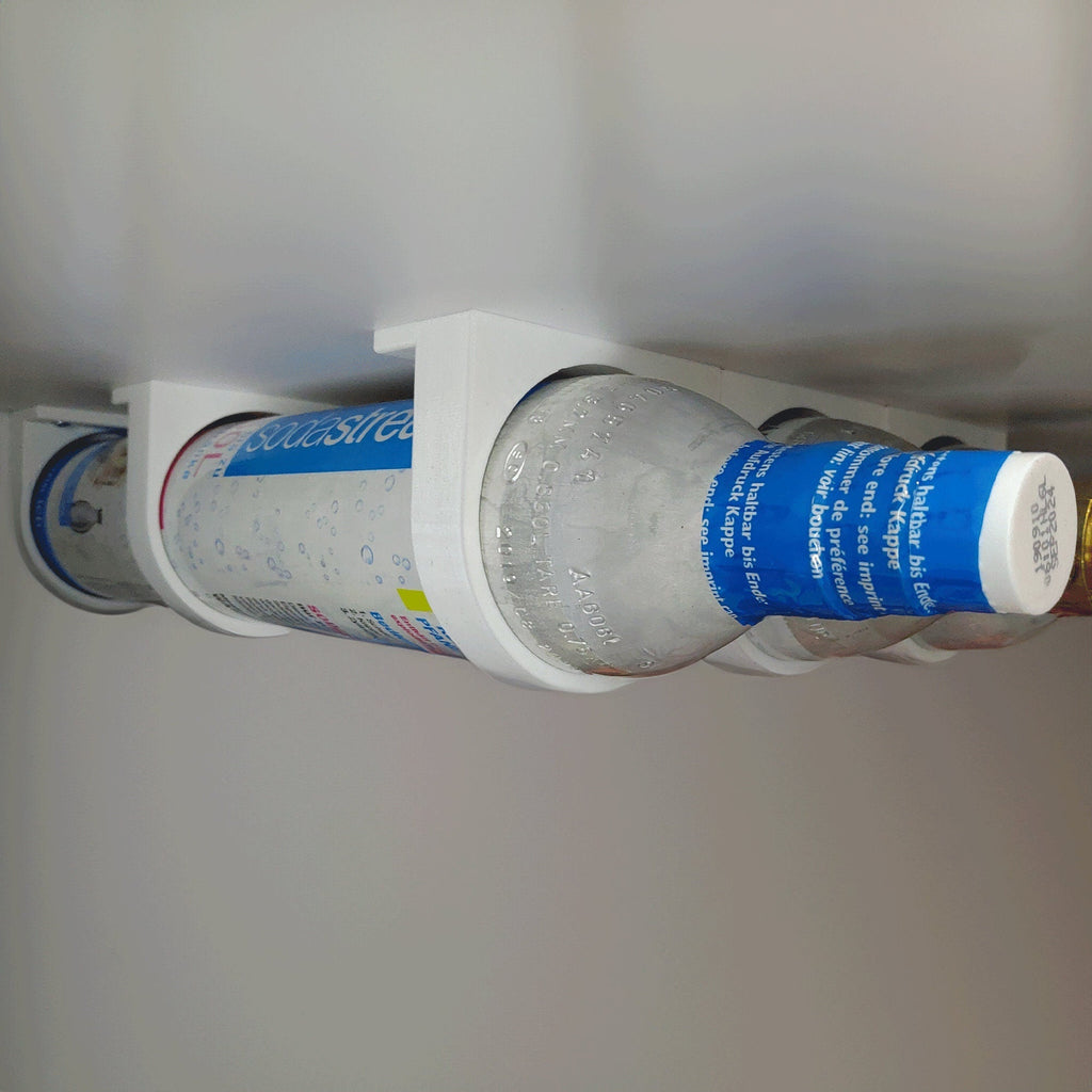 Wall mount rack holding spare SodaStream 60L CO2 cylinders under a cabinet, view 3