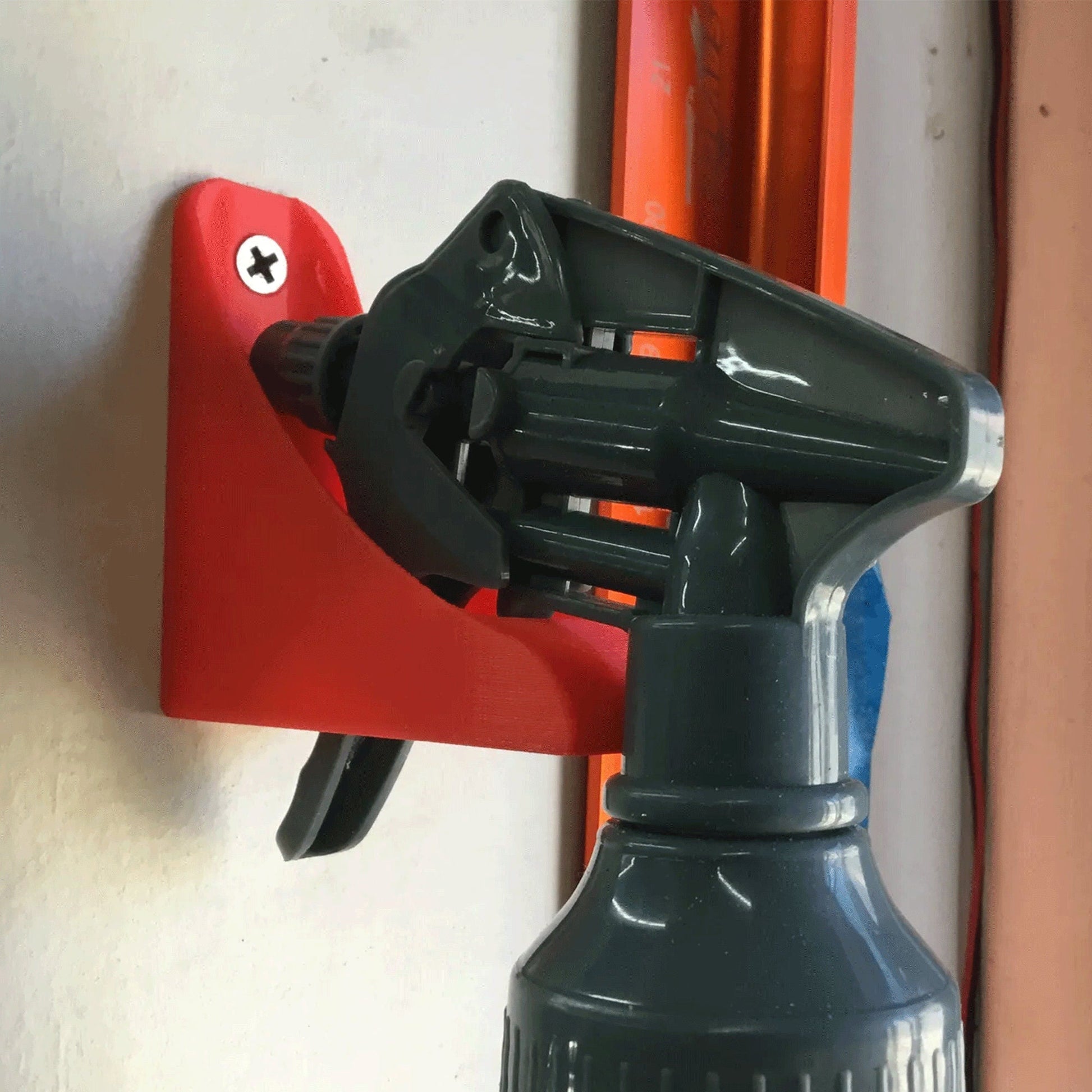 a red and black spray bottle on a wall