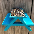 Squirrel picnic table feeder with bench seats mounted on a fence
