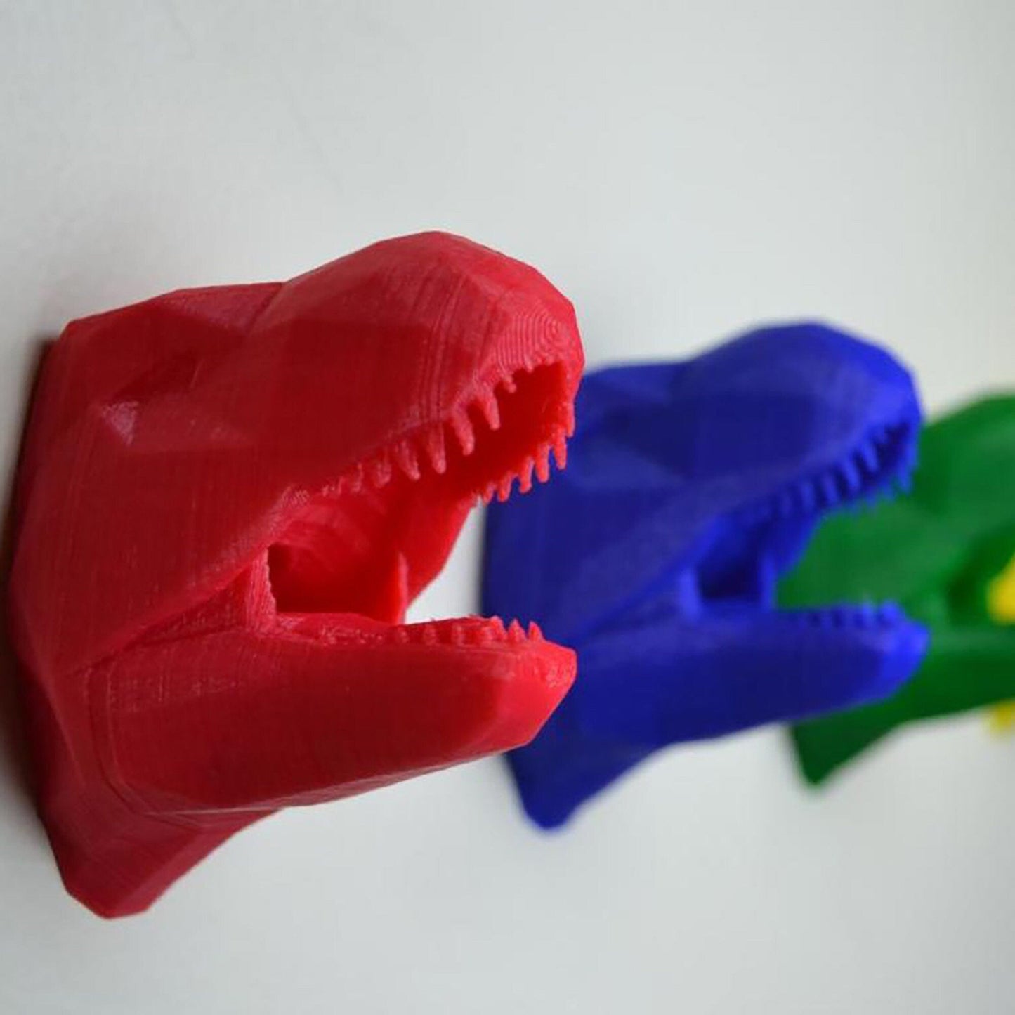 a close up of two plastic dinosaurs on a wall