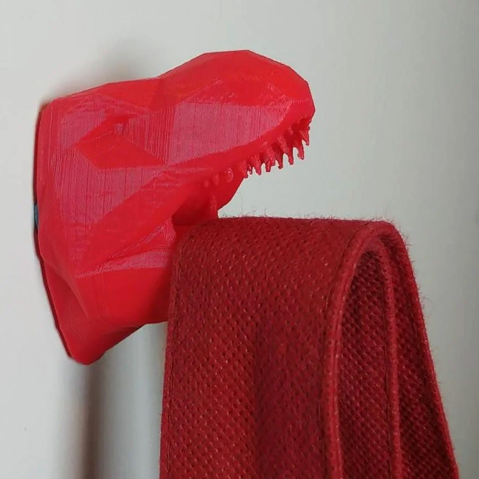 a close up of a red object hanging on a wall