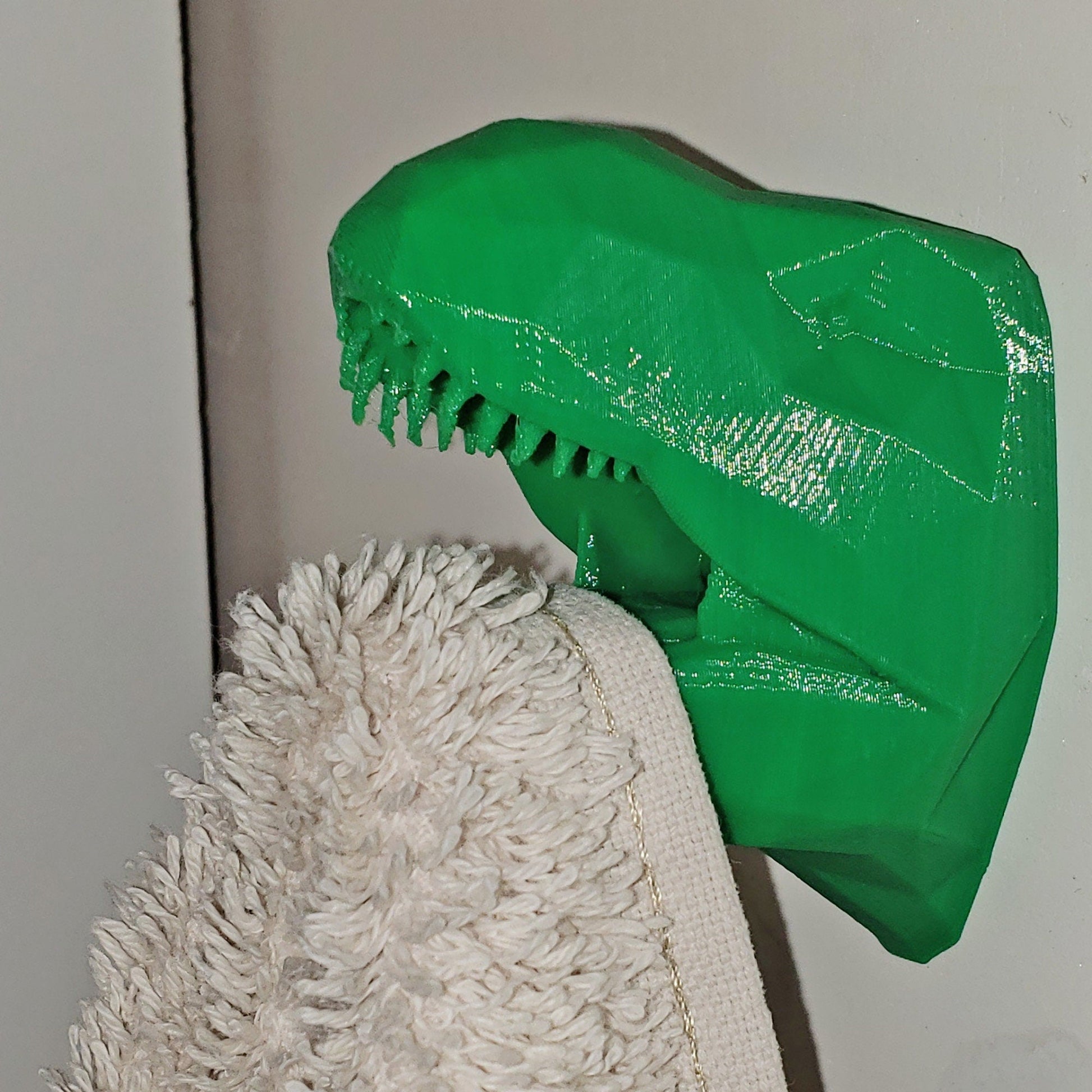 a close up of a green plastic dinosaur head