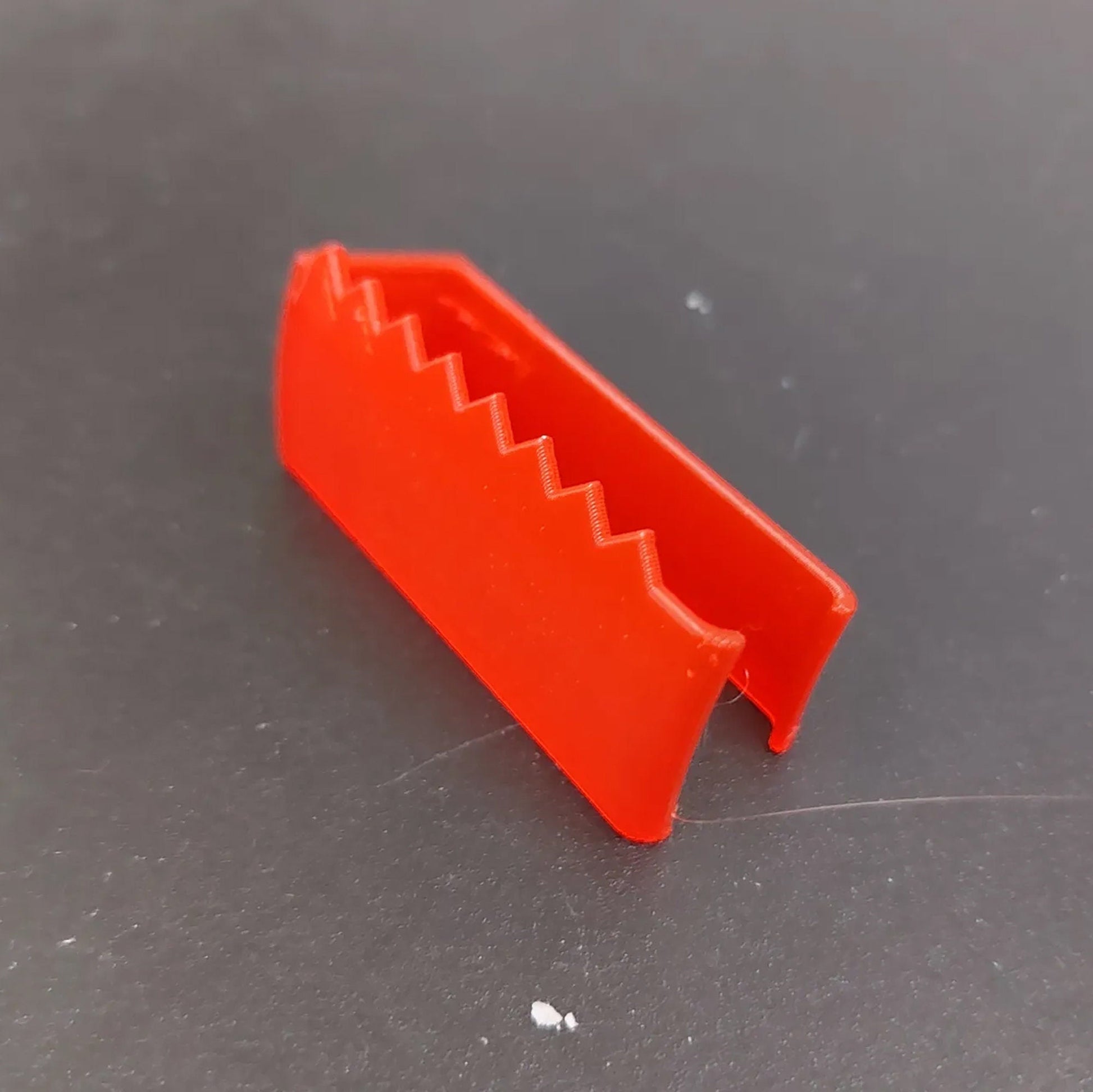 a red plastic object sitting on top of a table