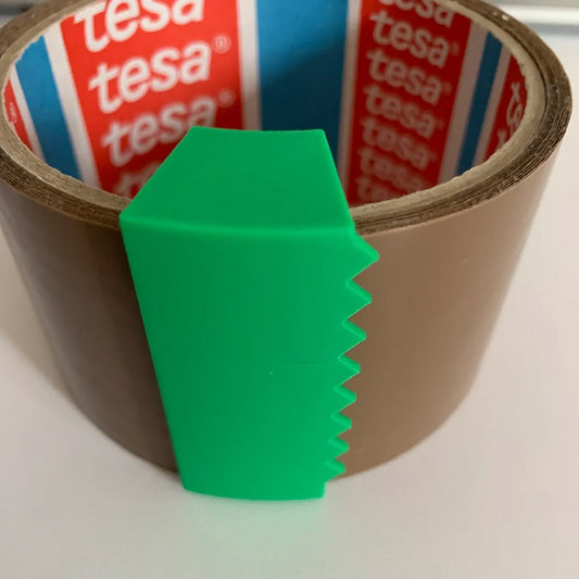 a roll of tape with a green piece of paper sticking out of it