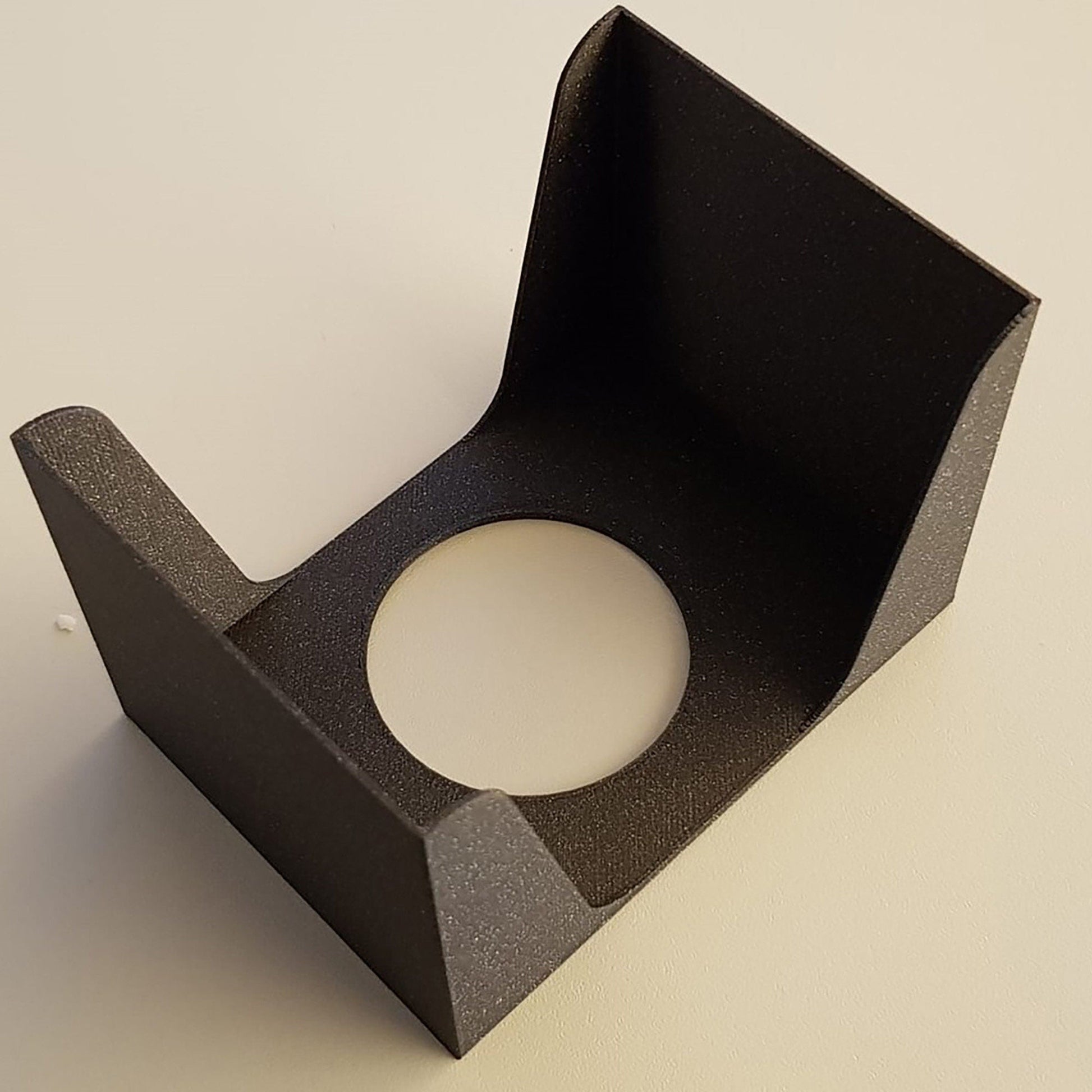 a black paper holder on a white table