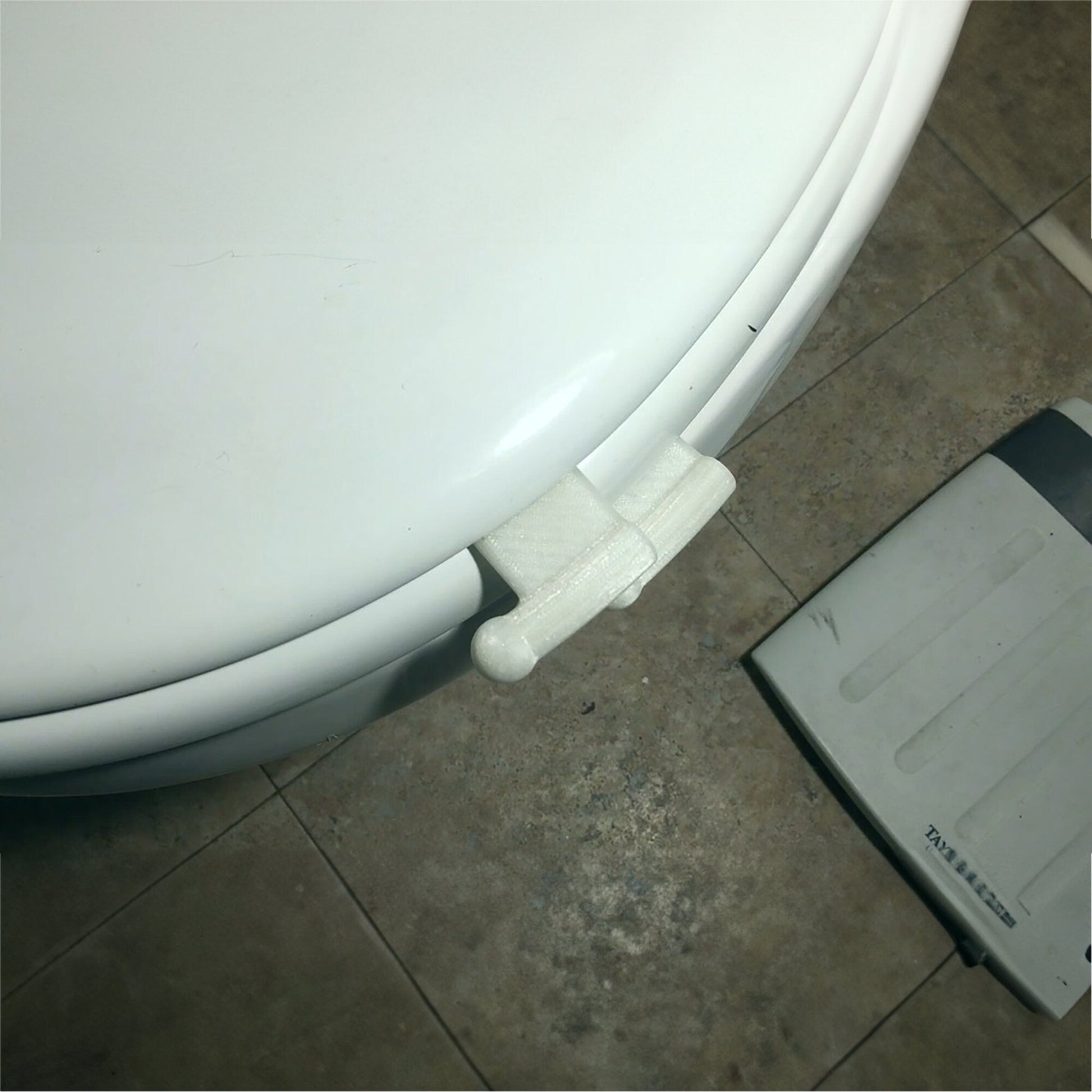 a white toilet sitting on top of a tiled floor