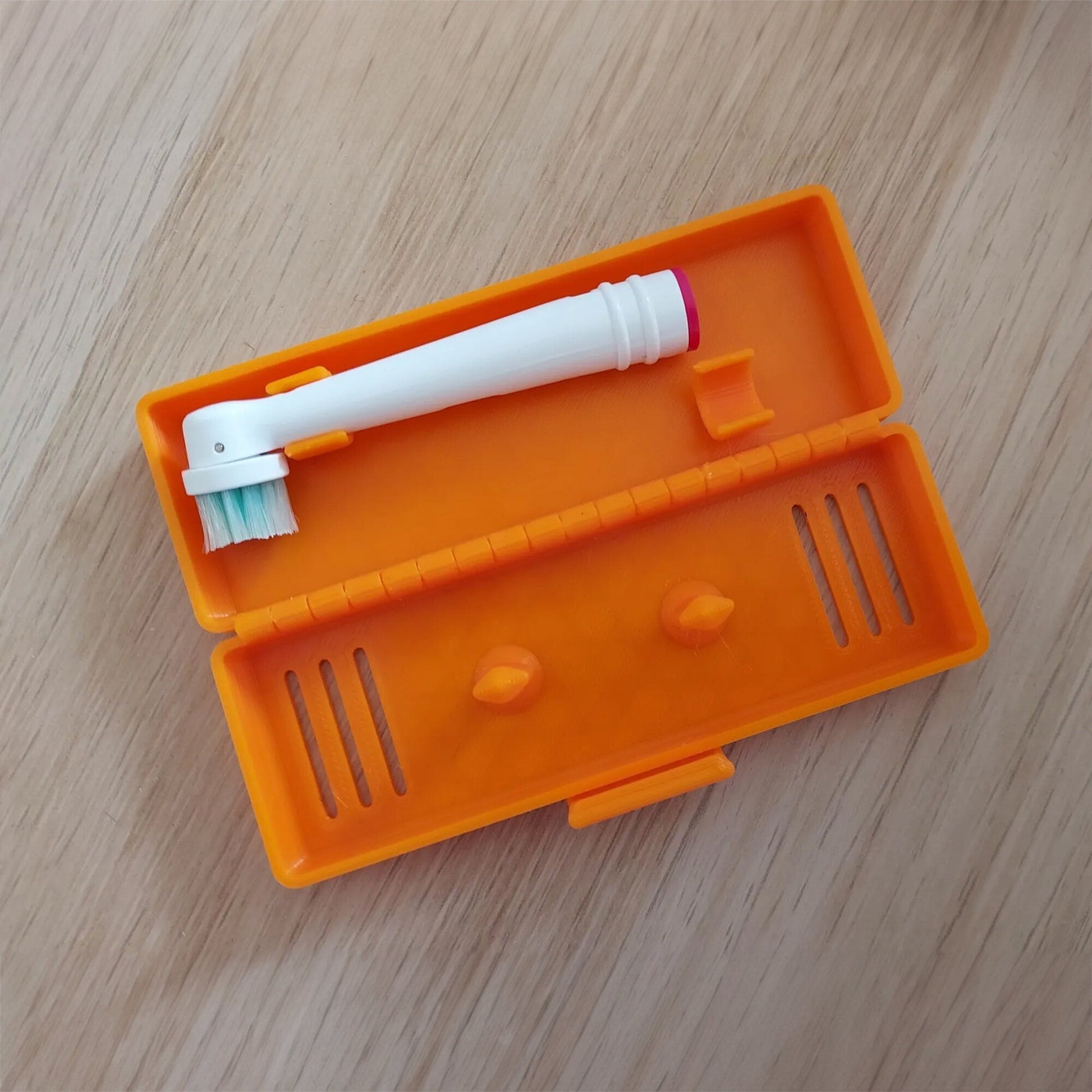 an orange plastic case with a toothbrush in it