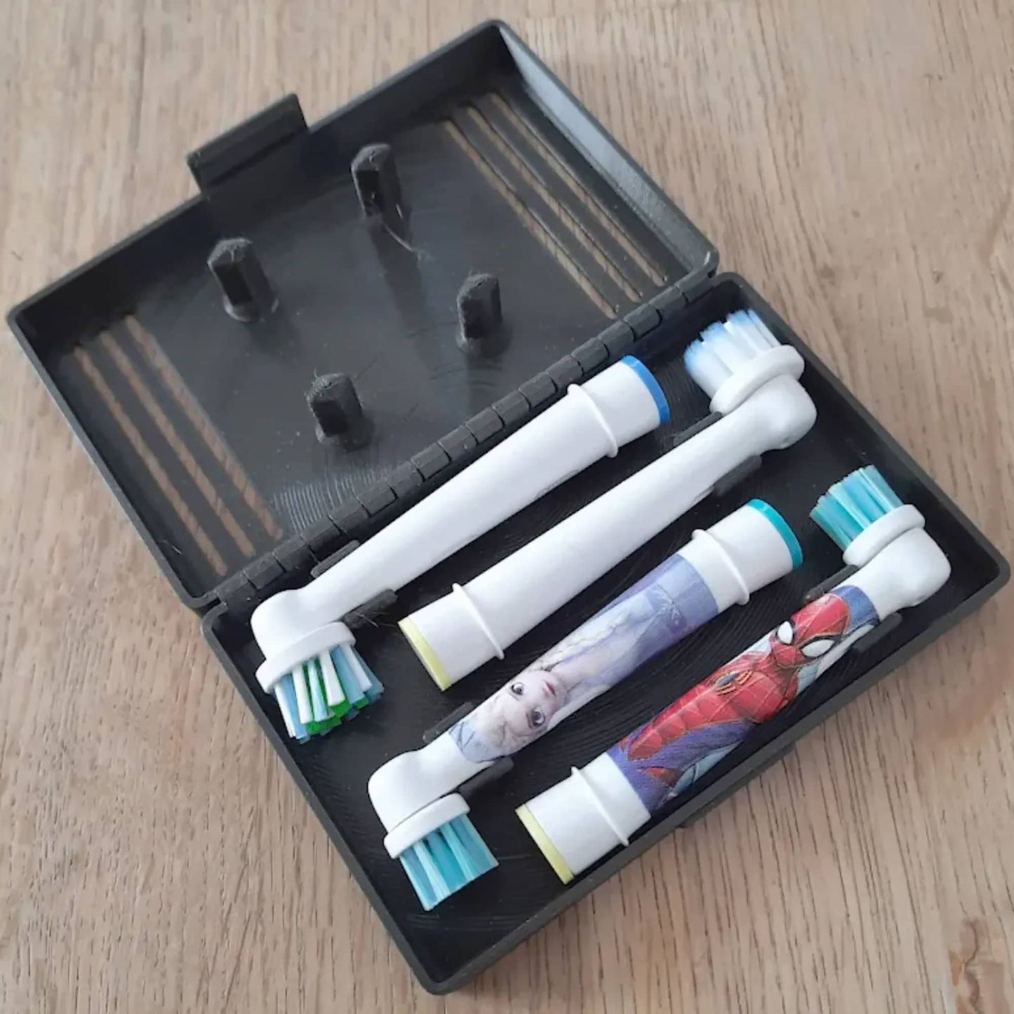 three toothbrushes in a black case on a wooden table