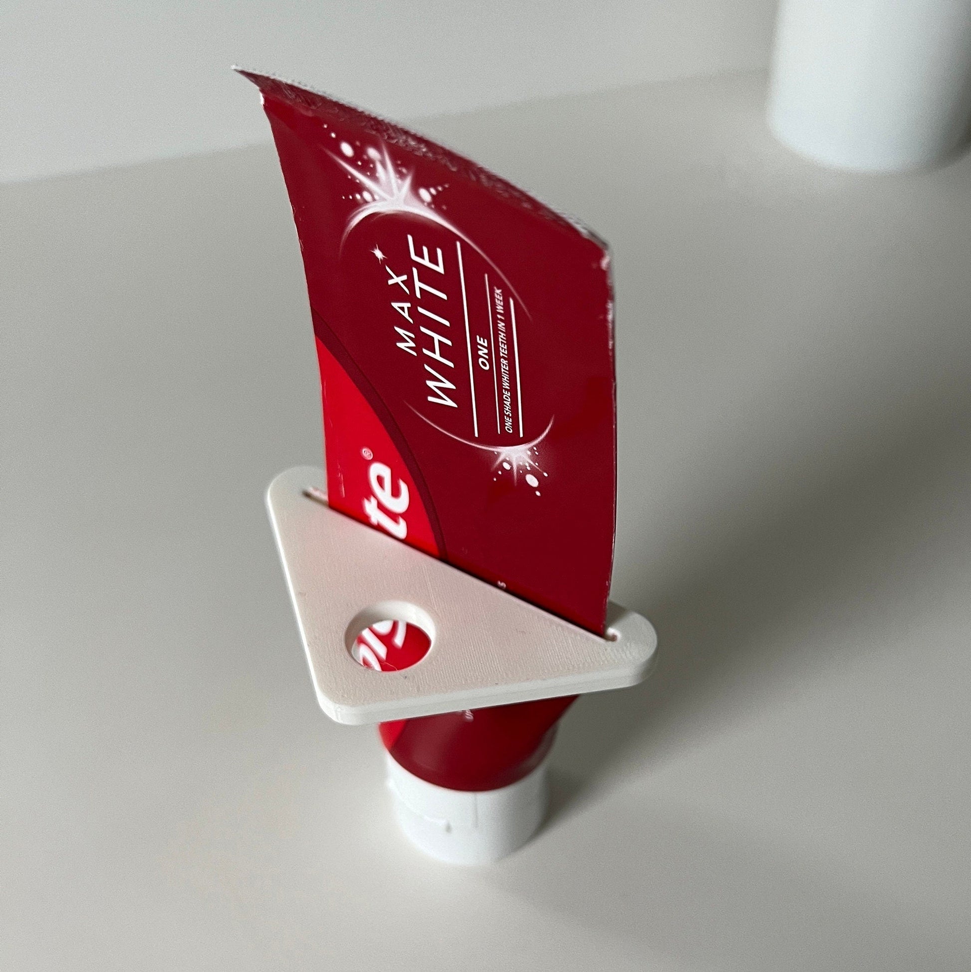 a white cup with a red sail on top of it