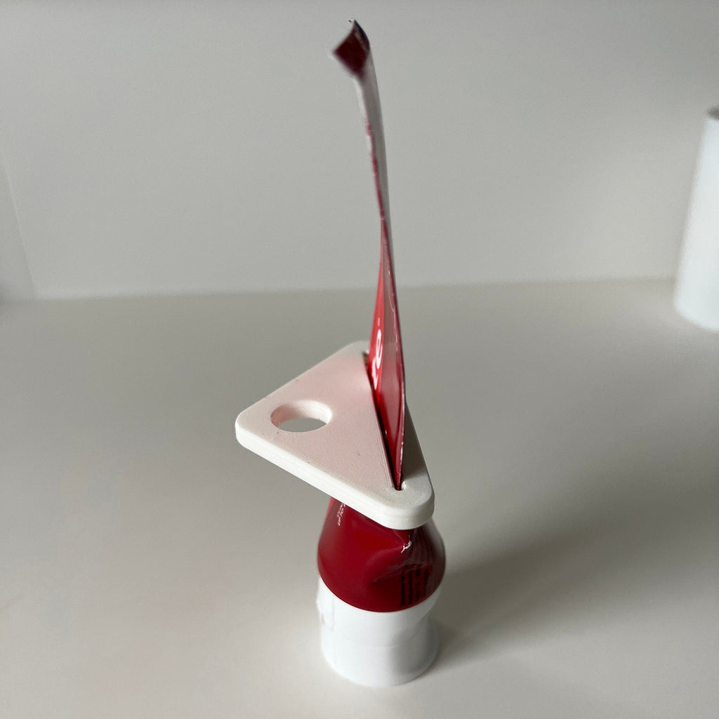 Toothpaste tube squeezer key rolling up a tube from the flat end, view 3