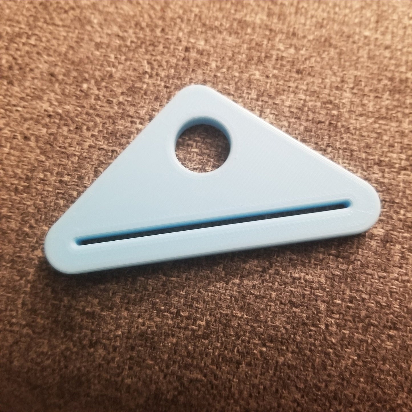 a blue plastic object laying on a brown carpet