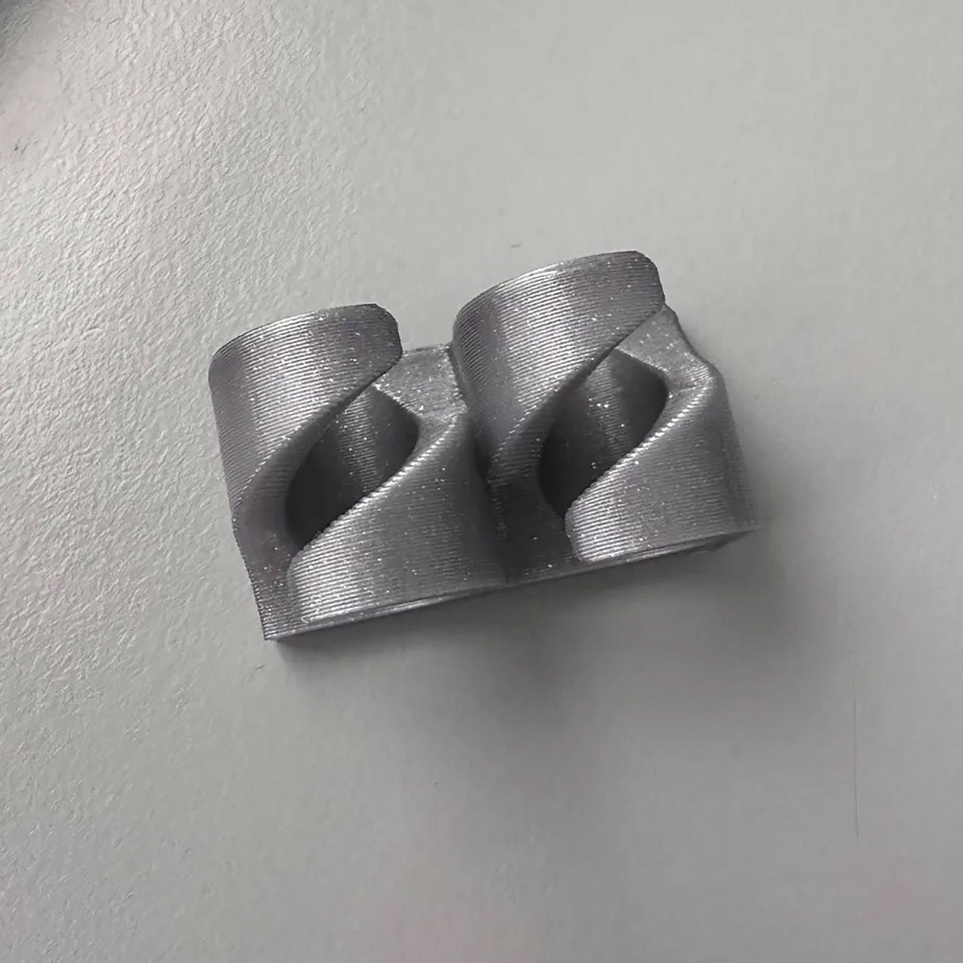 a pair of metal fittings on a white surface