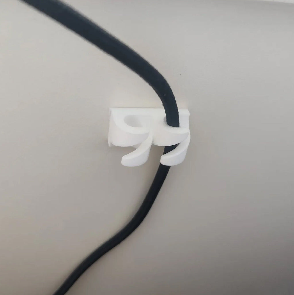 Adhesive cable clips holding USB and charging cords along a desk edge, view 4