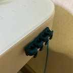 Adhesive cable clips holding USB and charging cords along a desk edge, view 5