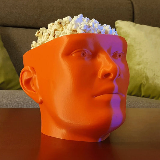 a man&#39;s head with a bowl of popcorn on top of it