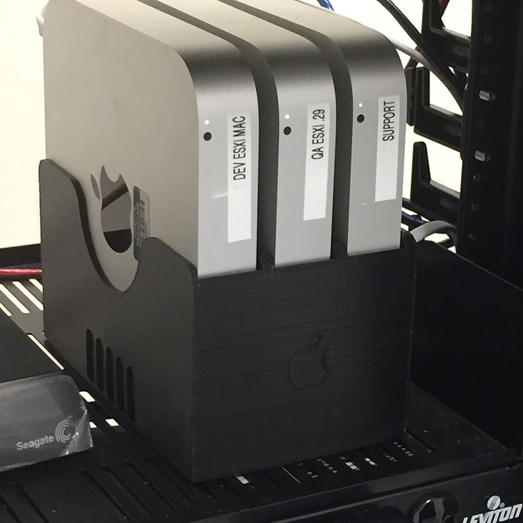 Multi-bay vertical rack holding several Apple Mac Mini units on edge, view 2