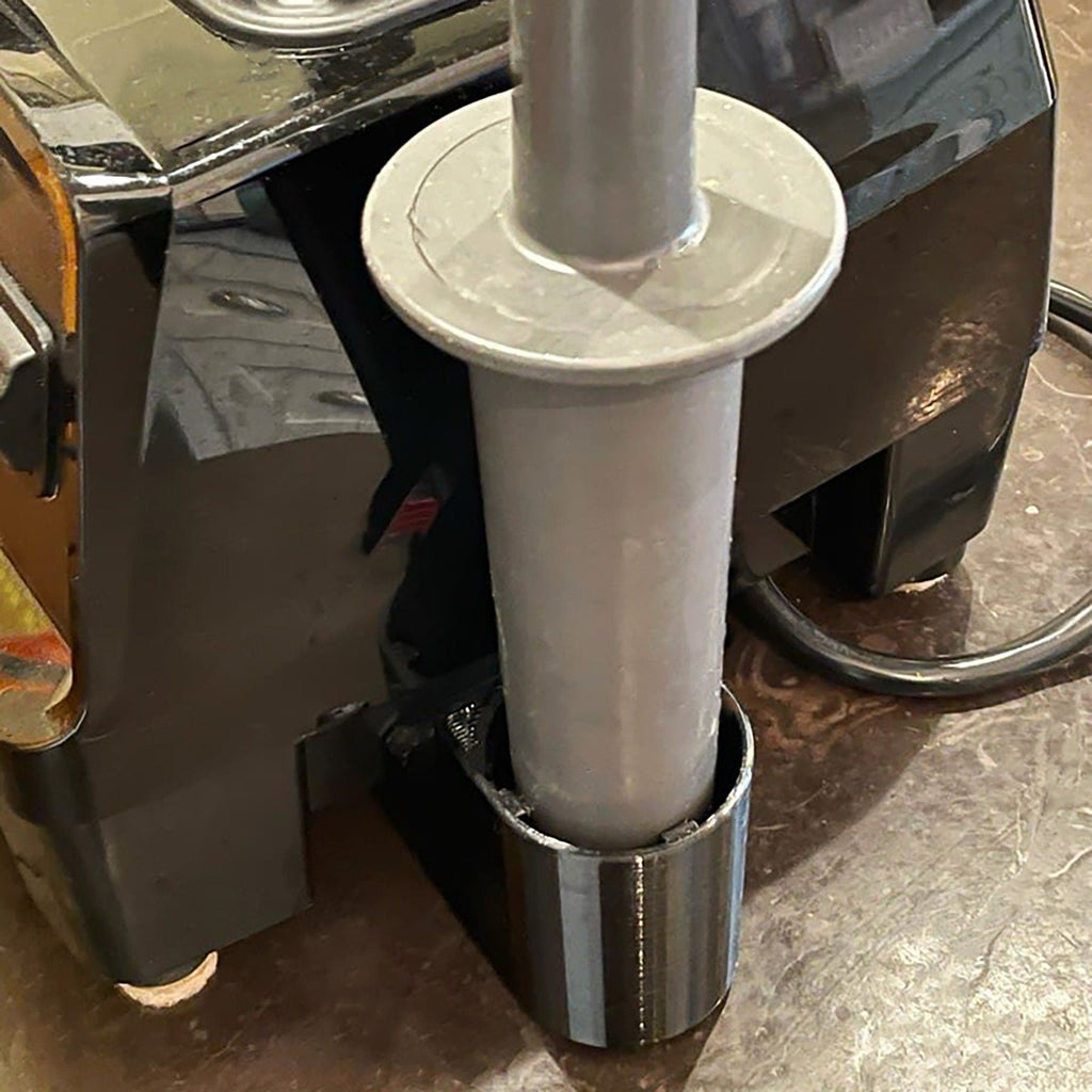 Side-mount tamper holder clipped to a Vitamix blender base, view 3