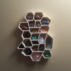 Honeycomb wall shelf displaying crystals and gemstones in hexagonal cells