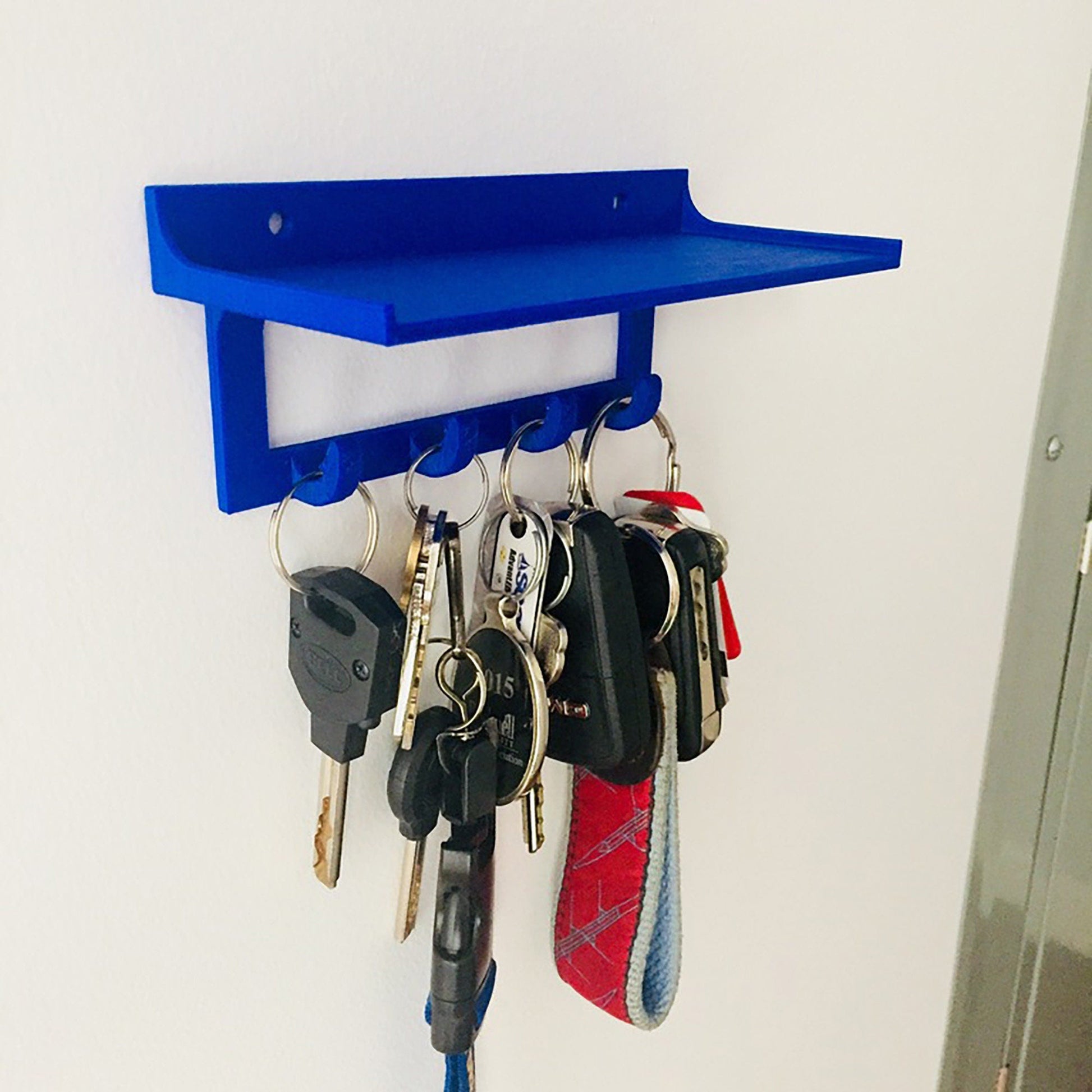 a bunch of keys hanging from a blue shelf