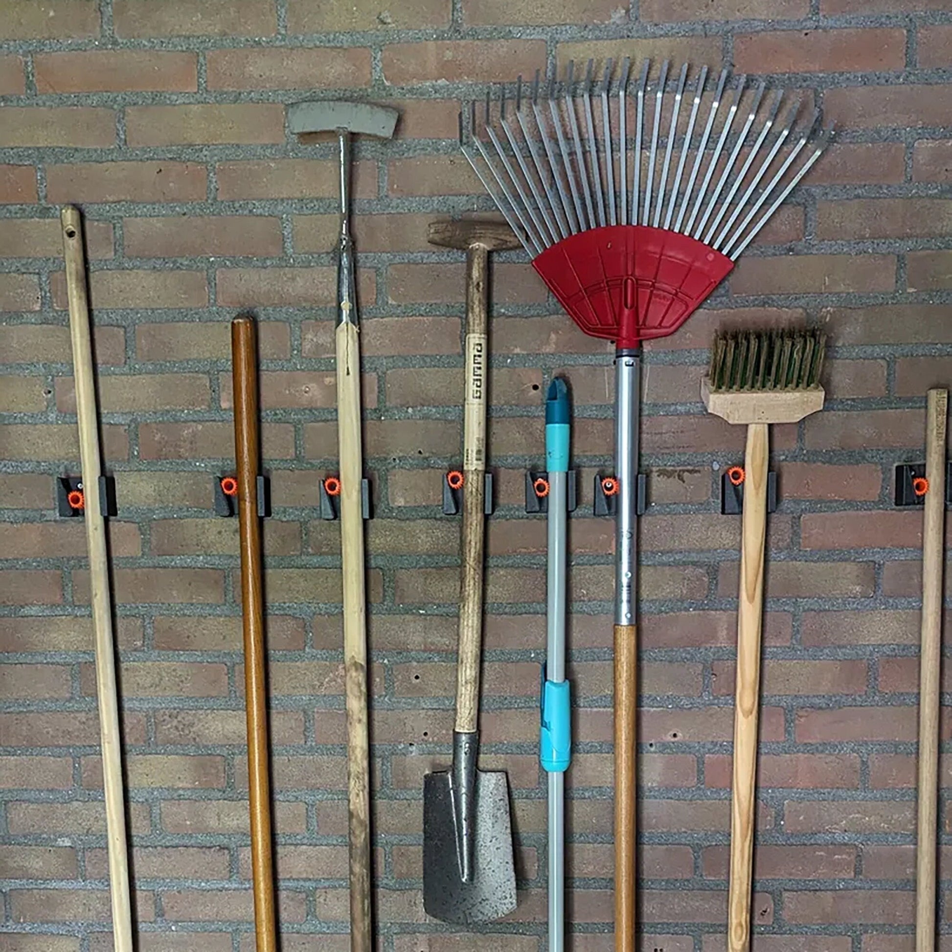 a bunch of tools are hanging on a brick wall