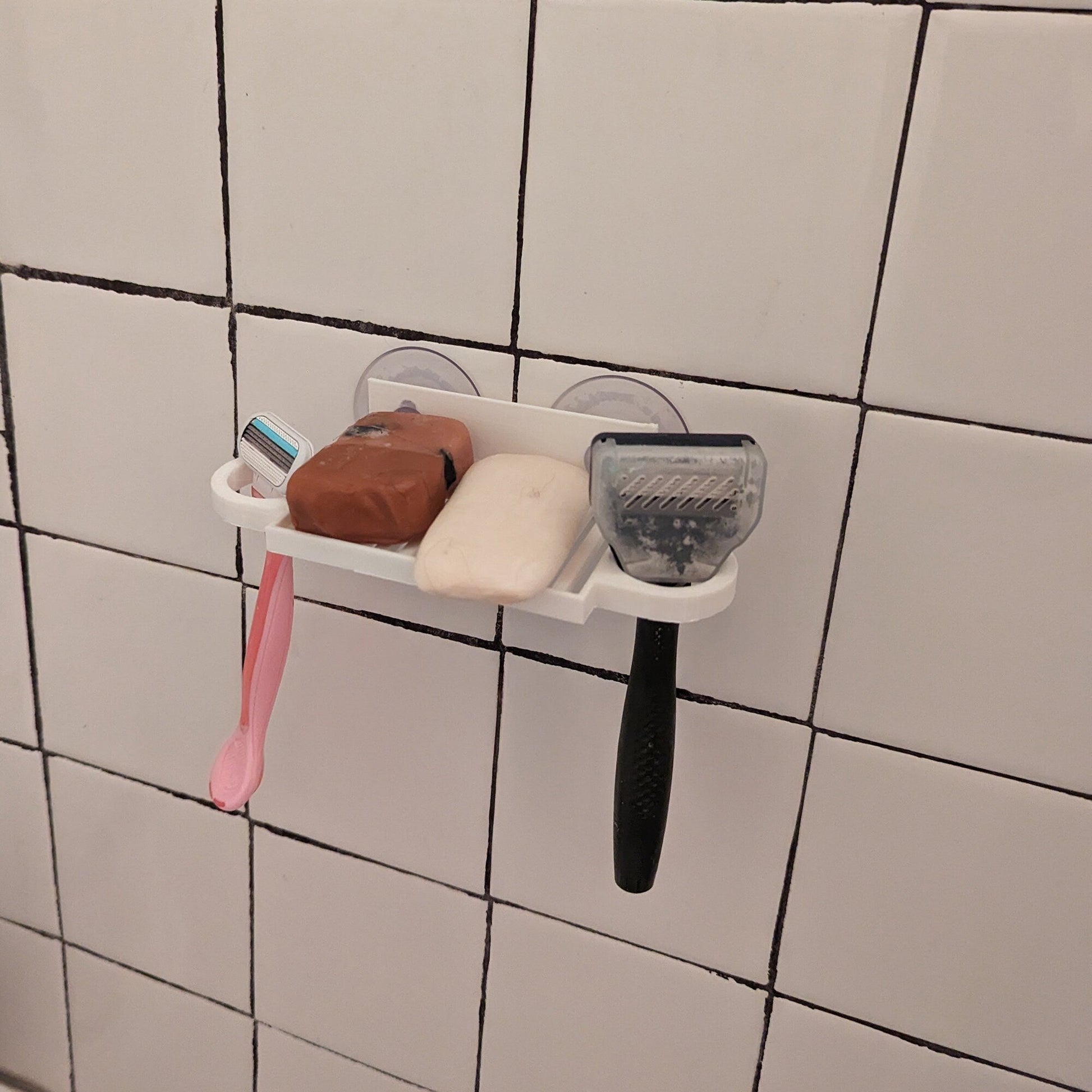 a bathroom wall with a toothbrush, soap, and toothpaste on it