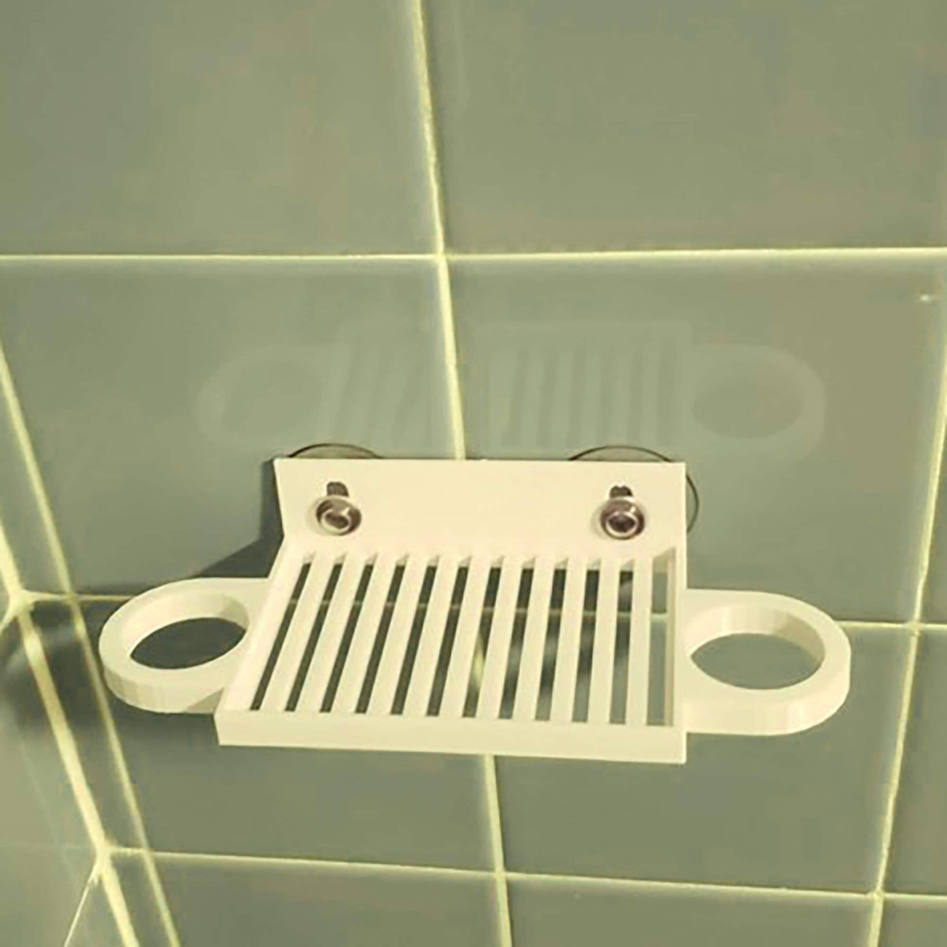 a close up of a toilet paper dispenser on a tiled wall