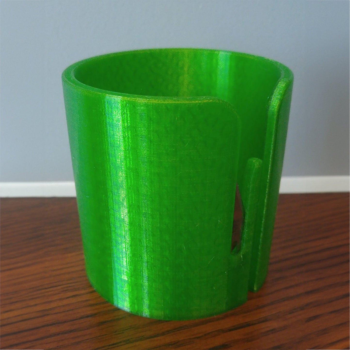 a green cup sitting on top of a wooden table