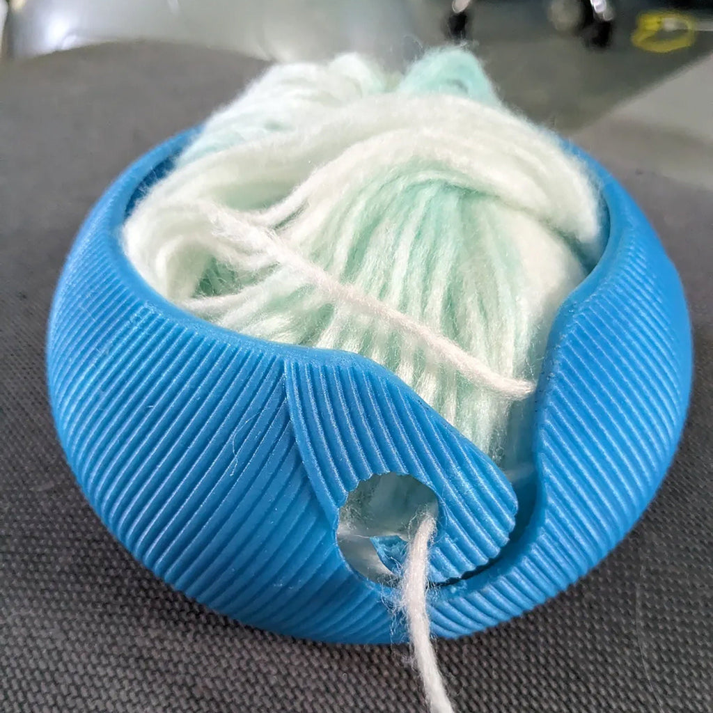 Yarn bowl with swirl cutout for knitting and crochet, holding a ball of yarn, view 2